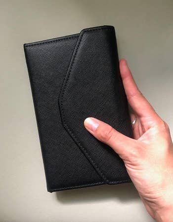 reviewer holding black wallet