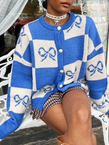 model in blue and cream check and bow pattern sweater