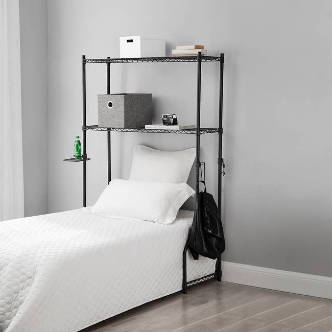 gray over the bed storage shelf with bins on it