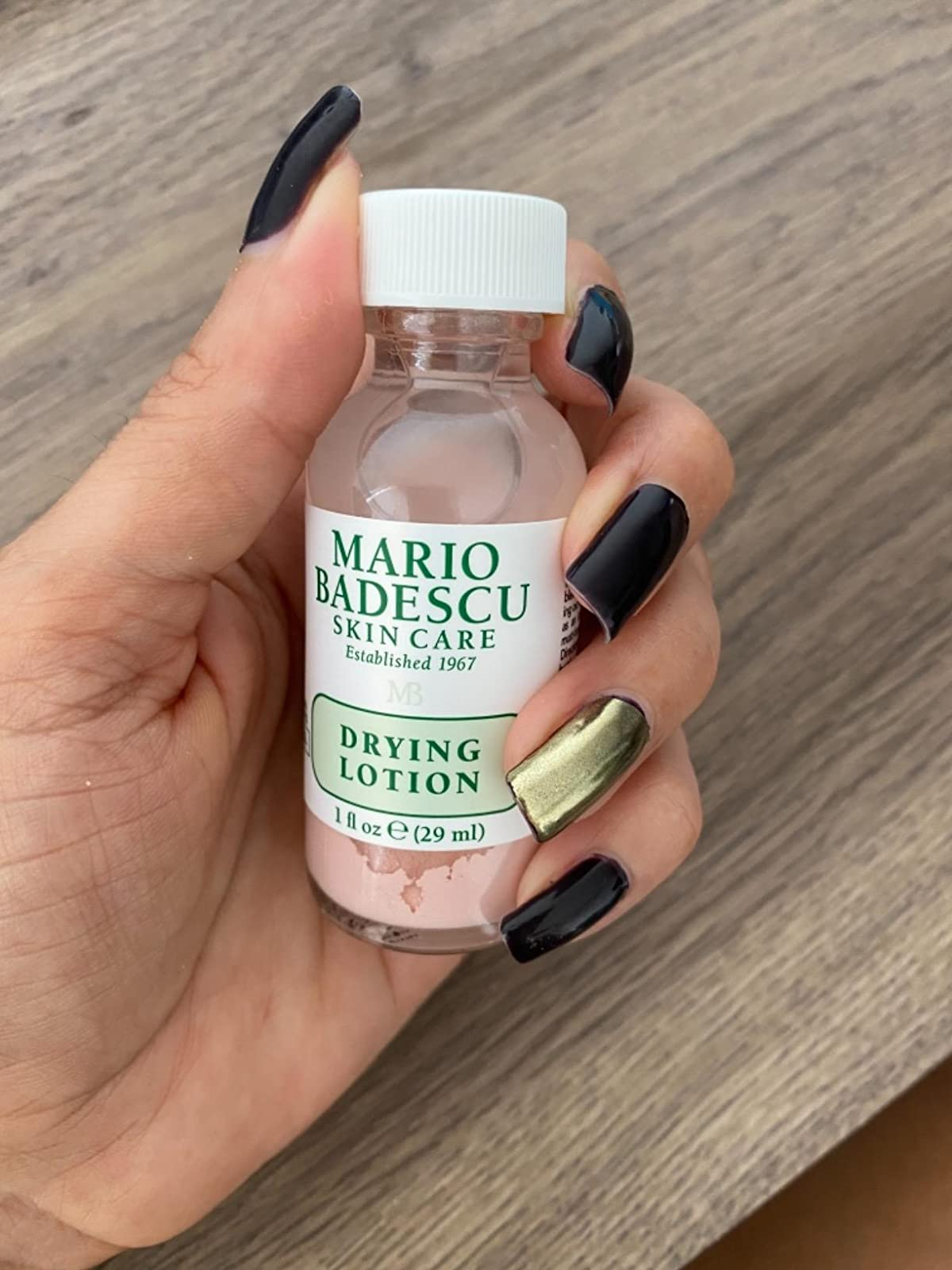 Reviewer holding their Mario Badesco drying lotion