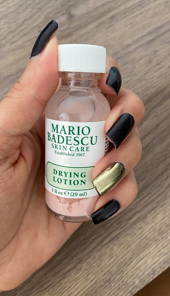 Reviewer holding their Mario Badesco drying lotion