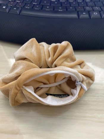 Beige fabric scrunchie on a desk with a keyboard in the background