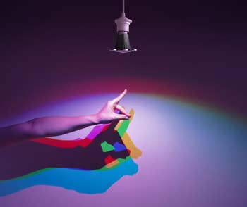A manus making shadiness puppets nether colored airy beneath a modern lamp, showcasing originative lighting effects