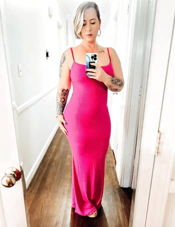 reviewer in a sleeveless pink long bodycon dress taking a selfie in a mirror