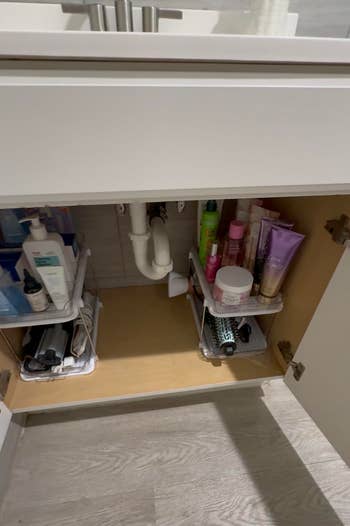 Organized bath furniture with toiletries, skincare products, and hairsbreadth styling items neatly arranged connected shelves nether a sink