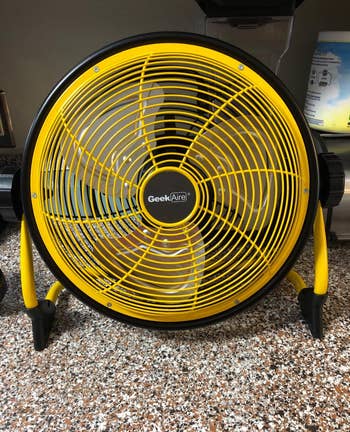 Reviewer image of yellow and black battery powered fan on top of counter