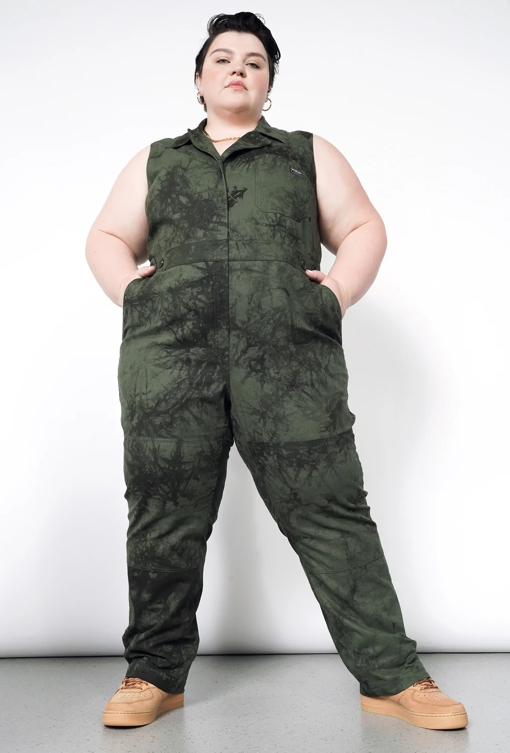 a plus size model wearing the marble dyed sleeveless coveralls