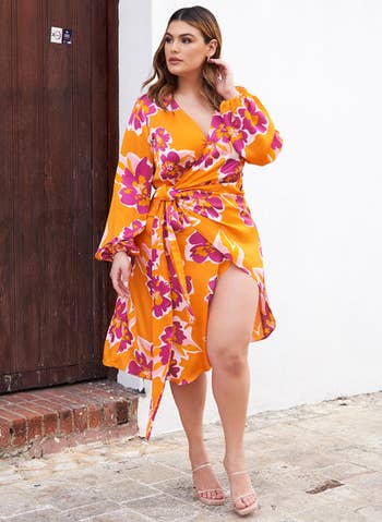 front view of a model in the orange and pink floral wrap dress