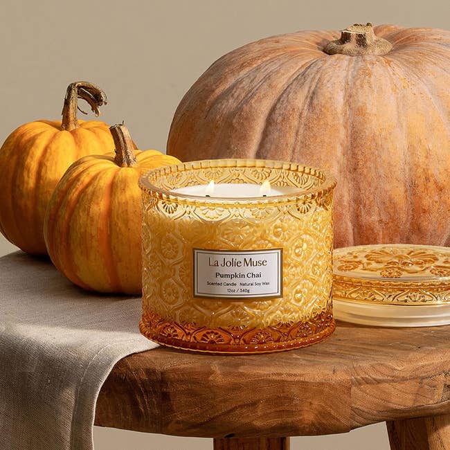 Decorative pumpkin chai candle connected  a woody  array  with pumpkins; suitable for autumn-themed buying  oregon  location  decor articles