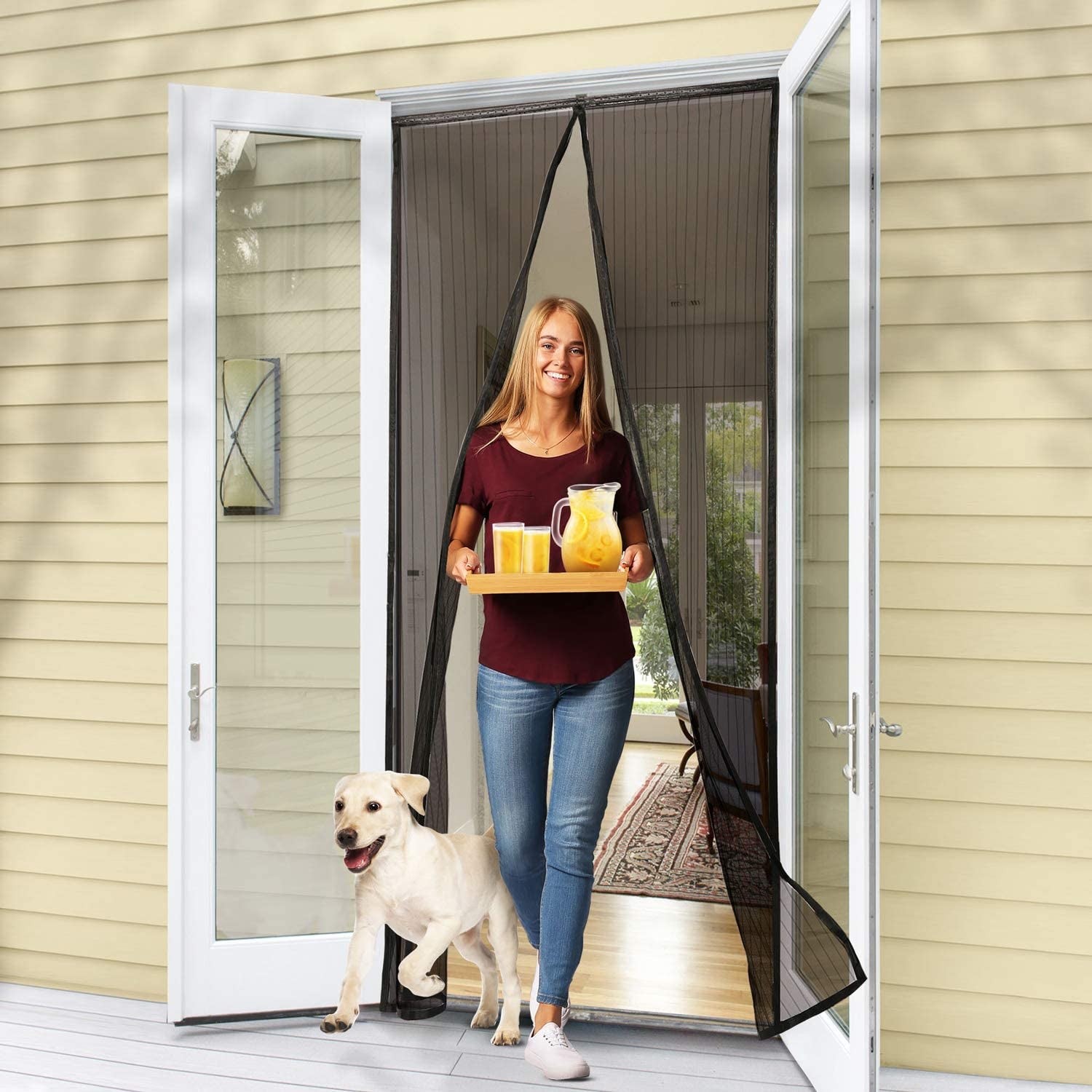 Model easily walking through the instant screen door with hands full of beverages and a dog in tow