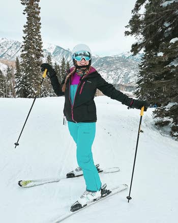 reviewer wearing the turquoise overalls in the snow