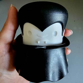 a reviewer manus  holding the vampire-shaped ail  crusher 