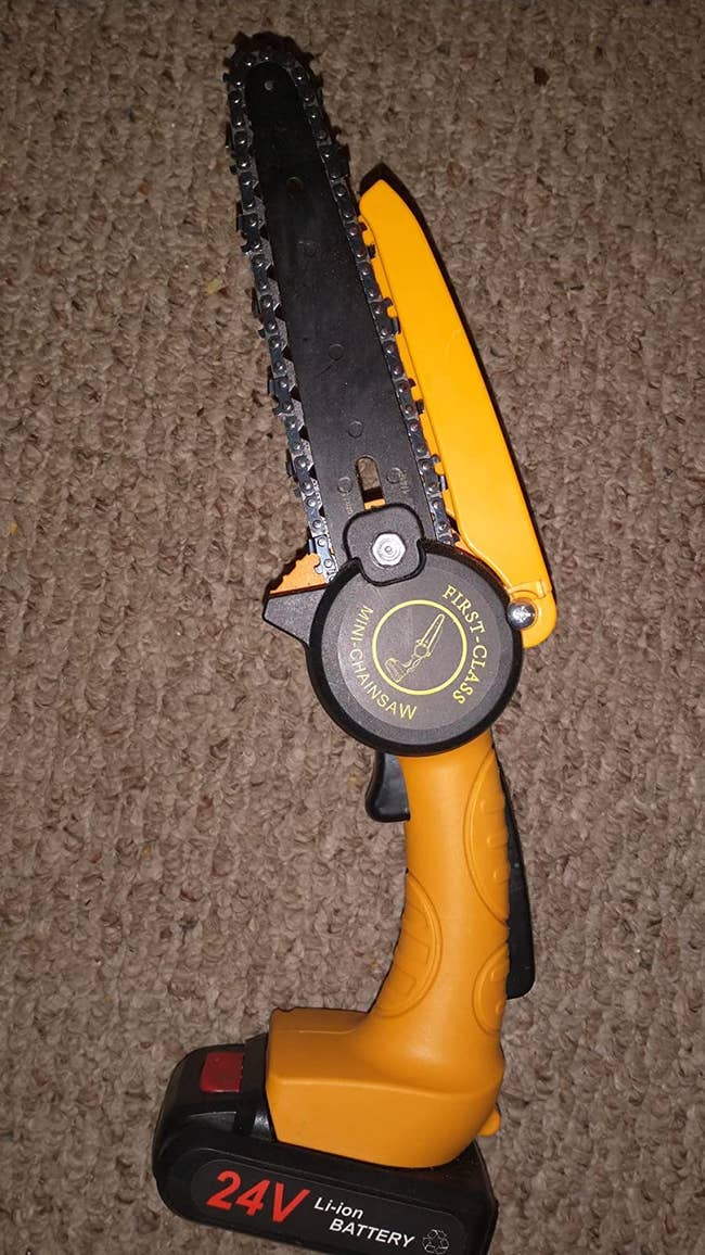 a reviewer photo of the mini chainsaw in orange 