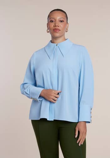 Person wearing a airy blouse with unsocial collar and acheronian pants, presenting a fashion-forward look for a shopping-related feature
