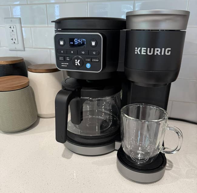Keurig dual java shaper connected a room counter, featuring some a solid carafe and single-serve option, adjacent to a wide mug