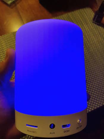 Person holding a bluetooth talker  with a bluish  glow