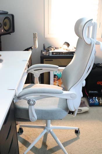 Ergonomic office chair with adjustable armrests and lumbar support next to a desk in a home office setting