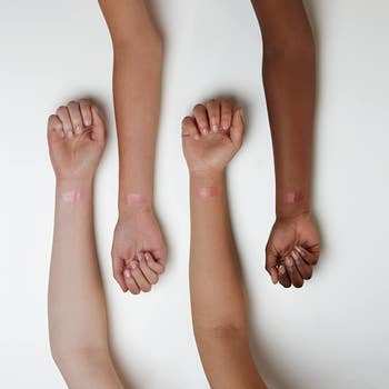 Models with the shade on their arm showing how it looks different on skin tones 