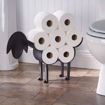 sheep-shaped toilet paper holder stacked with rolls next to toilet