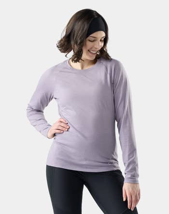 Person wearing a long-sleeve apical  and leggings, smiling portion    looking down