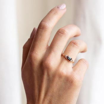 a model wearing the dainty emerald ring