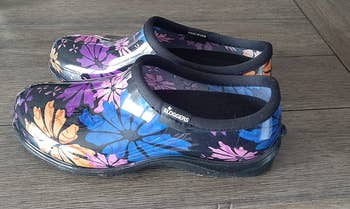 A closeup of the shoes in black with a colorful flower design