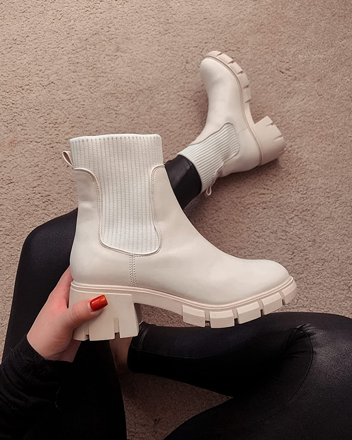 reviewer photo of them holding a white chunky Chelsea boot in one hand and then wearing the other on their foot