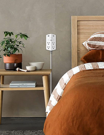the surge protector set up next to a bed