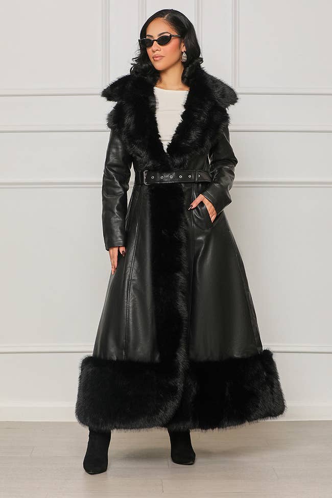 a model wearing a longline faux leather coat with faux fur trim