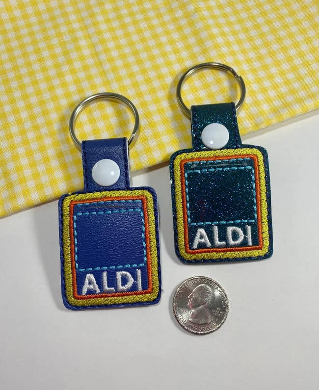 A small square-shaped keychain embroidered with the Aldi logo with a space for a quarter 
