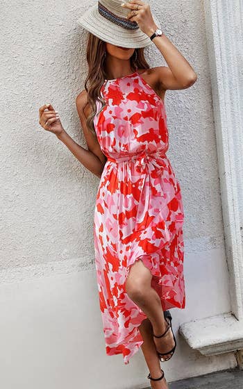 model wearing the halter dress in a red and pink pattern