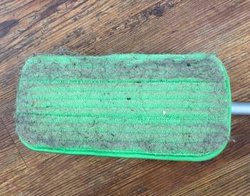 a reviewer's mop pad showing all the dust and dirt it collected