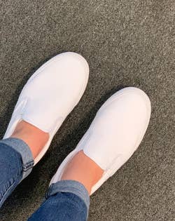 reviewer wearing the white slip ons