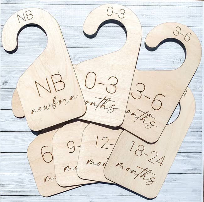 seven wooden closet dividers with sizes printed on it
