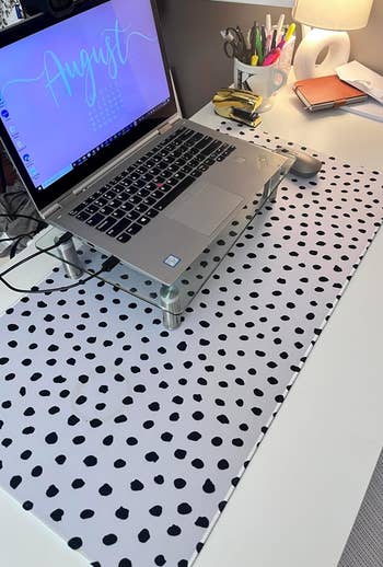 a white desk mat with black polka dots on it
