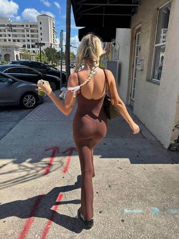a reviewer wearing the dark brown jumpsuit, showing back of jumpsuit