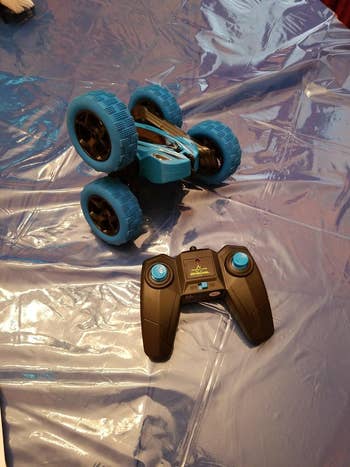 reviewer's blue remote-control car next to black remote