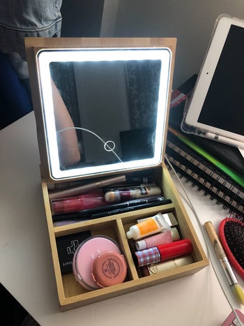 reviewer photo of lit mirror inside bamboo makeup box