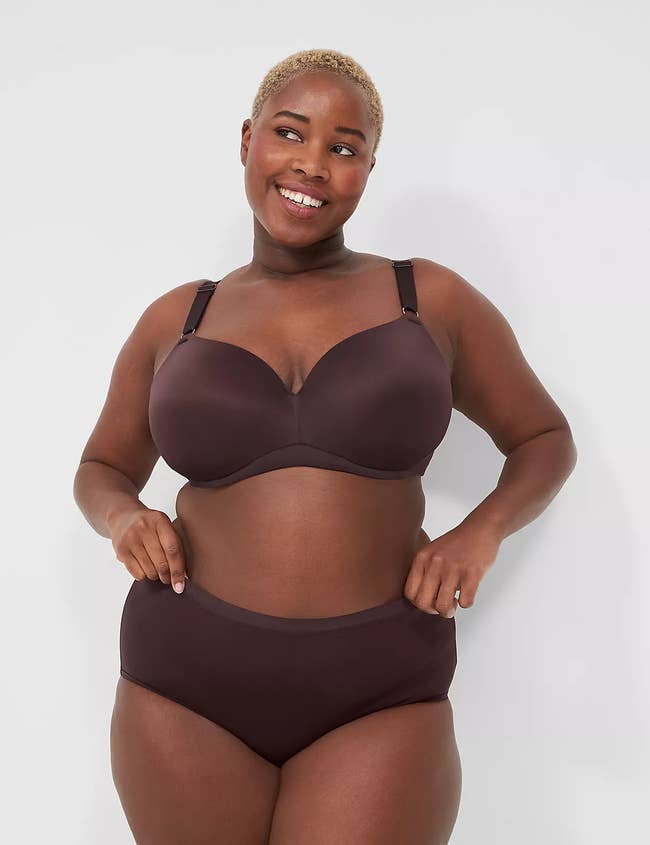 Model in matching brown balconette bra and high-waisted underwear, posing with hands on hips