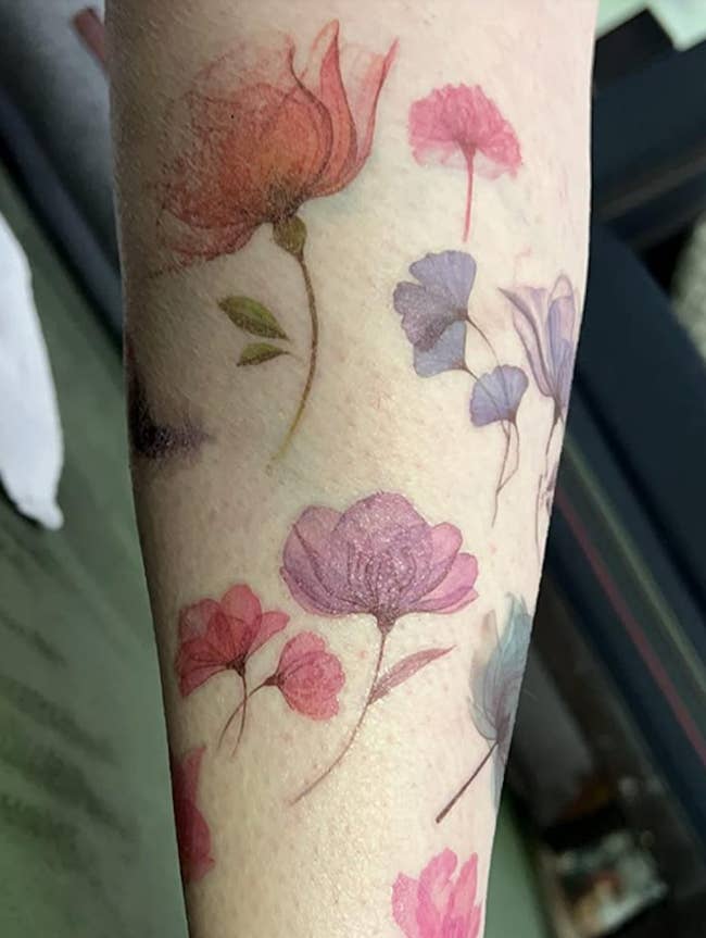 Floral tattoos successful assorted styles and sizes connected an arm