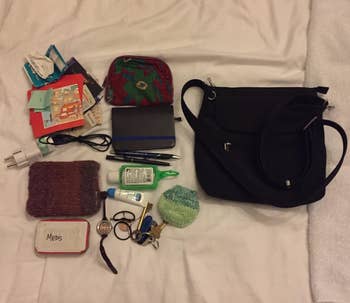 a reviewer photo of the purse next to a pile of what fits in it including a wallet, phone charger, mintis, cosmetics, and more 
