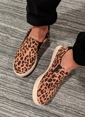 reviewer wearing the leopard print dr scholls sneakers