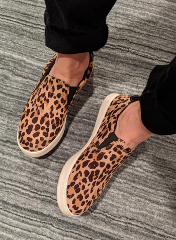 reviewer wearing the leopard print dr scholls sneakers