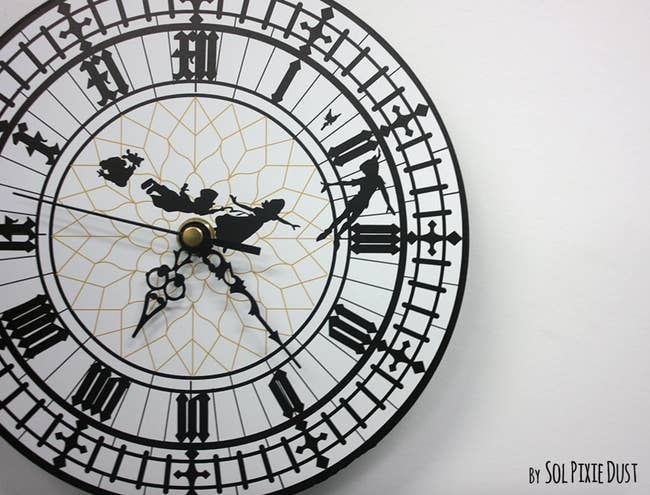 a big ben wall clock with decals of peter pan and co across it