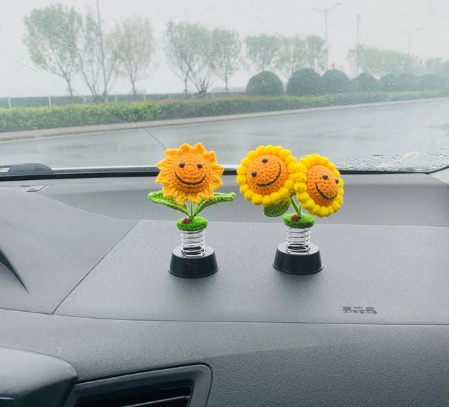 Two figurines, one sunflower, and the other is of two sunflowers