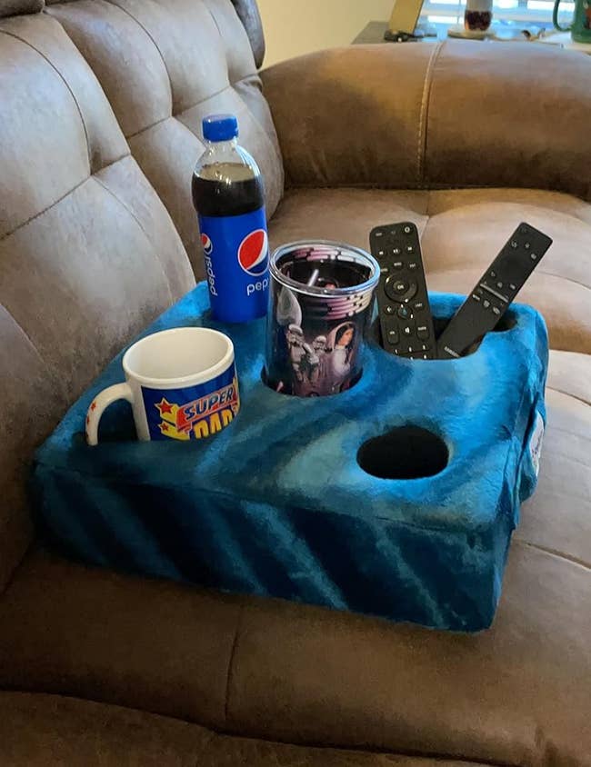 reviewer image of the teal Cup Cozy holding drinks and TV remotes