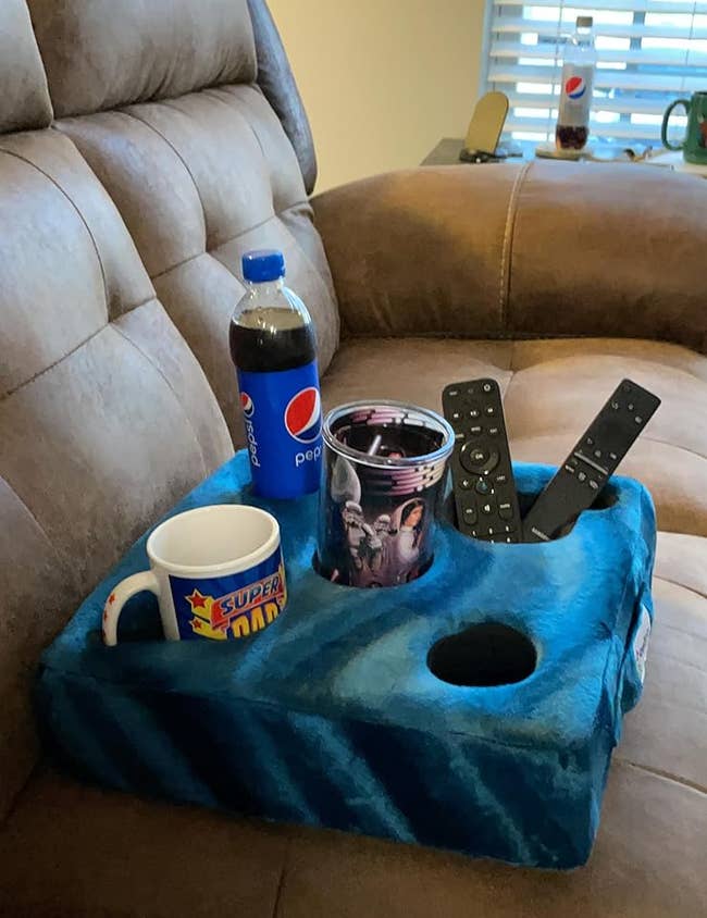 reviewer image of the teal Cup Cozy holding drinks and TV remotes