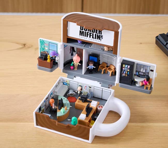 Miniature replica of an bureau acceptable with tiny figurines, depicting a fashionable TV show's firm environment, featuring desks and bureau décor