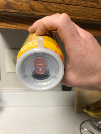 the cover closed over the opening of a can tilted on its side to show that the cover is leakproof