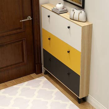 a shoe storage cabinet with black, yellow, and white doors
